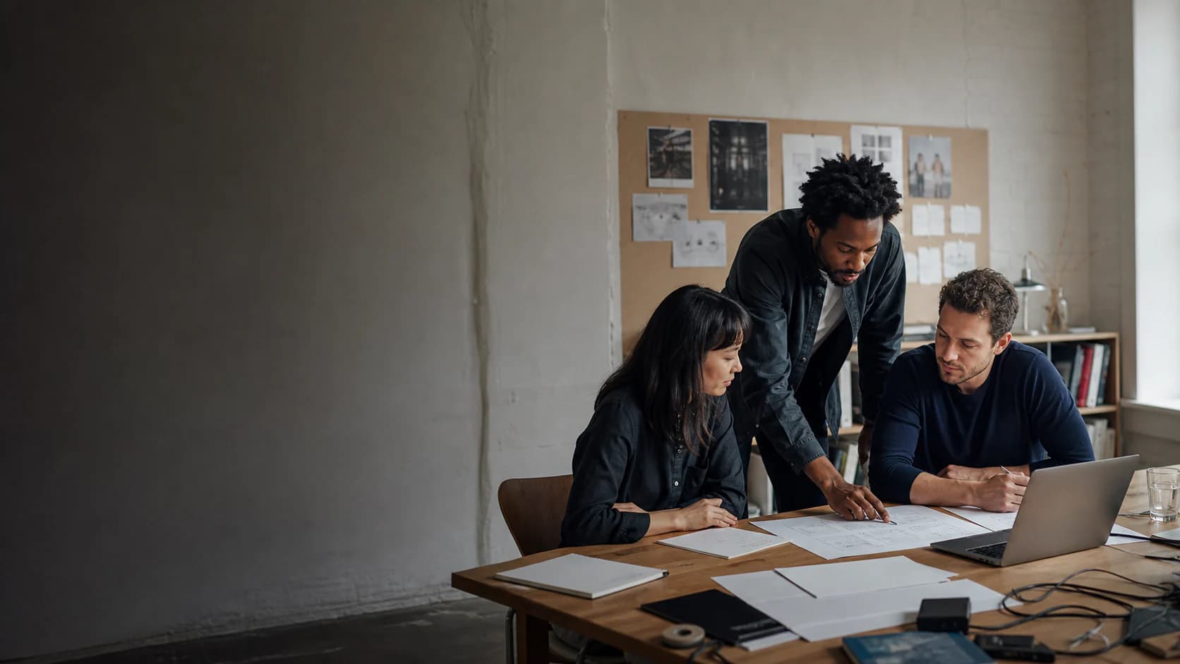 Three digital professionals planning a software project around a studio table