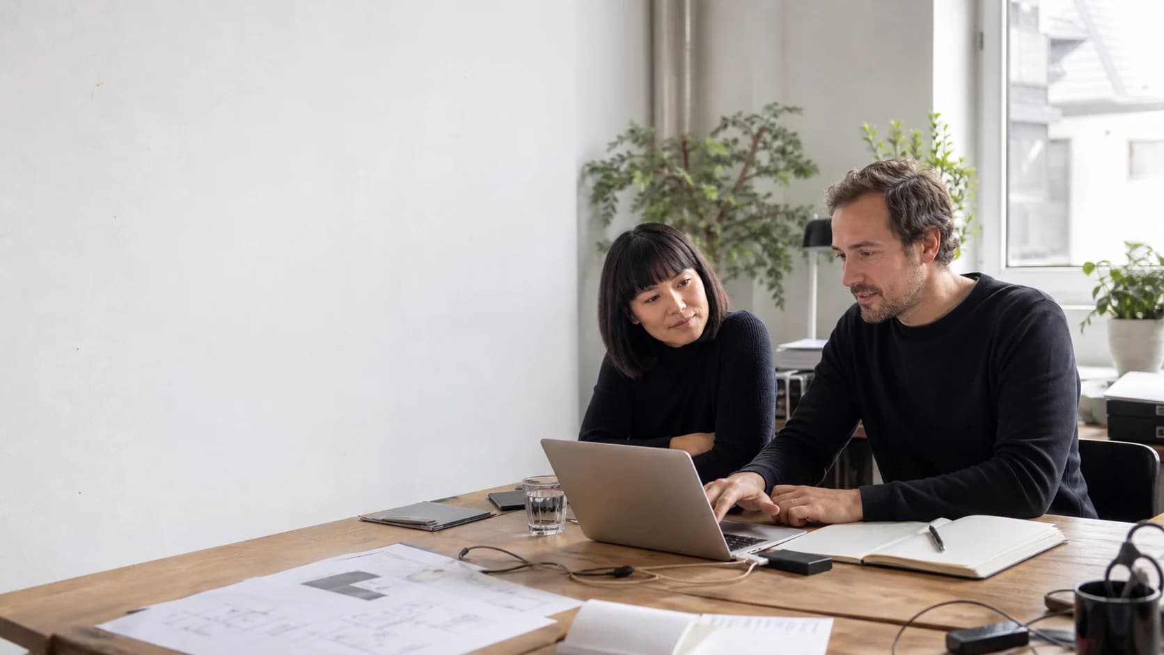 Two digital professionals reviewing a web product together at a studio table